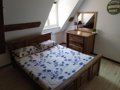 a bedroom with a bed and a dresser with a mirror at La Grande Terrine - Gîtes Les Potiers in Kaysersberg