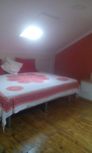 a bed in a room with a red wall at Aliciamar E by Casas de Setúbal in Setúbal