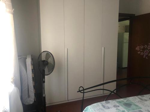 - une chambre avec une armoire blanche et un ventilateur dans l'établissement Casa di Armida, à Pavia