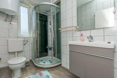 a bathroom with a shower and a toilet and a sink at Apartment Mandic in Omiš