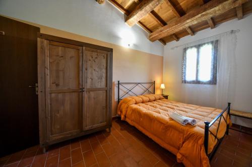 a bedroom with a bed and a large wooden door at AGRITURISMO LA VALLE DEI BRONZETTI in Cascia