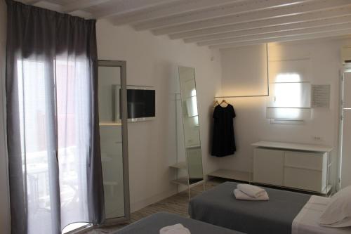 a room with a white refrigerator and a white bed at Christina Studios in Mýkonos City