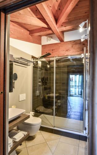 a bathroom with a glass shower and a toilet at Altezza in La Morra