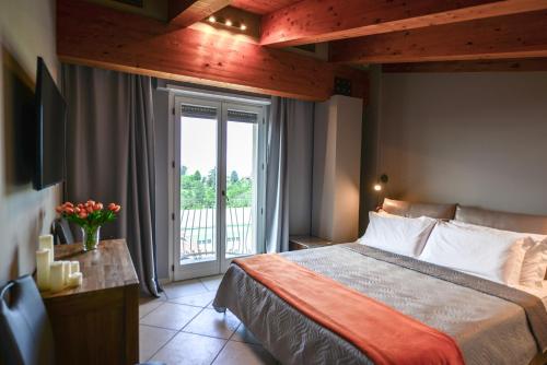a bedroom with a bed and a window with a balcony at Altezza in La Morra
