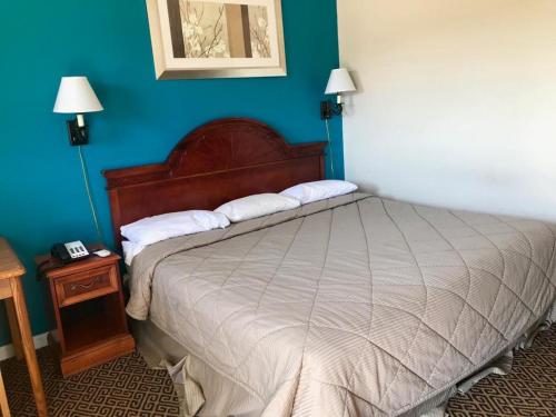 a bedroom with a bed and a blue wall at Lakeside inn in Eufaula