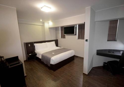 Habitación de hotel con cama y baño en qp Hotels Trujillo en Trujillo