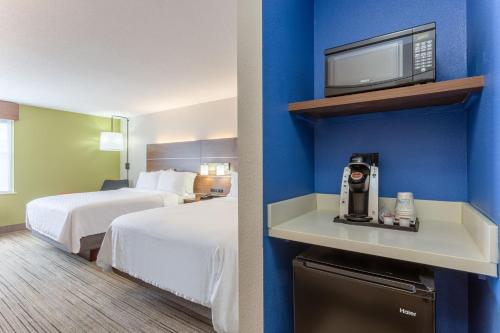a hotel room with two beds and a tv at Holiday Inn Express Scottsburg, an IHG Hotel in Scottsburg