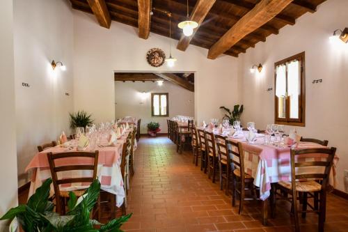 卡夏AGRITURISMO LA VALLE DEI BRONZETTI的宴会厅配有桌椅和粉红色的桌布