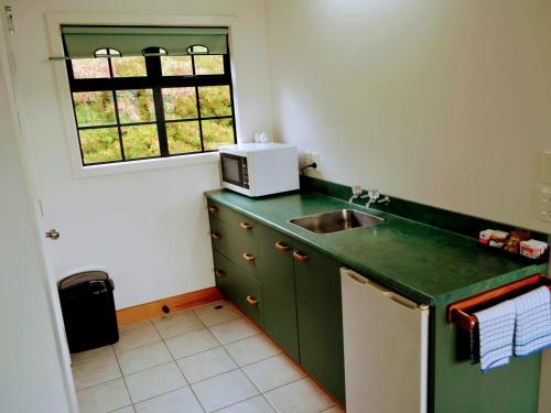 a small kitchen with a sink and a window at Salty Dog Inn in Snells Beach