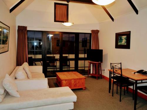 a living room with a couch and a table at Salty Dog Inn in Snells Beach
