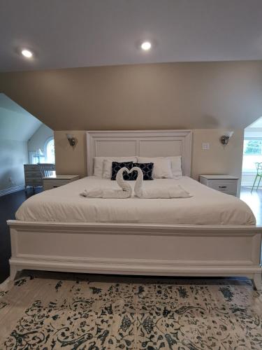 a bedroom with a large bed with two swans on it at By The River B&B in Fredericton