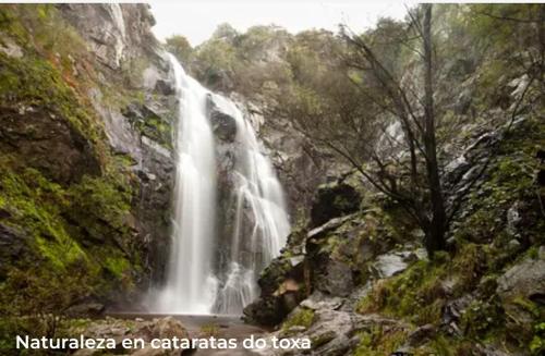 a waterfall on the side of a rocky mountain at APARTAMENTO EN EL CENTRO DE LALIN in Lalín