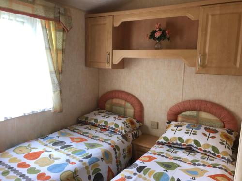 two twin beds in a small room at 74 Glenfinart Caravan Park in Dunoon