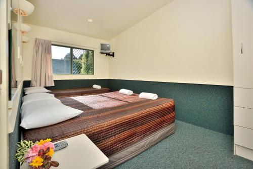 Ένα ή περισσότερα κρεβάτια σε δωμάτιο στο Auckland Northshore Motels & Holiday Park