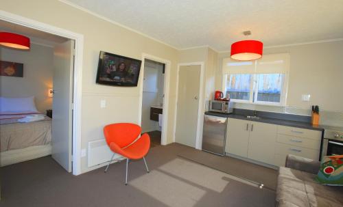a kitchen with an orange chair in a room at Wanaka View Motel in Wanaka