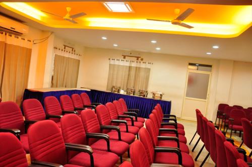 a room with red chairs in a conference room at Sayoojyam Residency in Palakkad