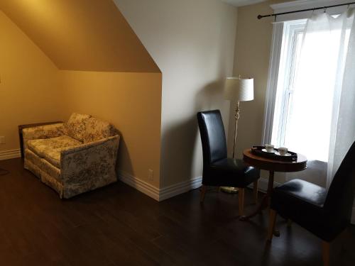 a living room with a couch and two chairs at By The River B&B in Fredericton