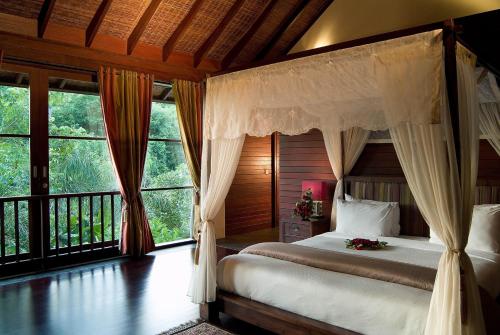 a bedroom with a bed and a large window at Gending Kedis Luxury Villas & Spa Estate in Jimbaran