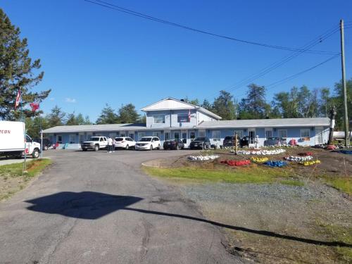 a large building with cars parked in a parking lot at Norvic Motel in Coniston