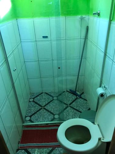 a bathroom with a toilet and a tiled floor at Suite Raio de Sol in Vale do Capao