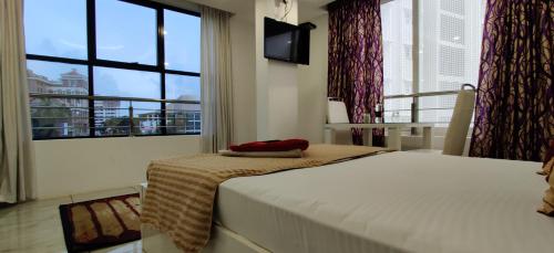 a bedroom with a bed and a large window at Rahul Residency in Mangalore