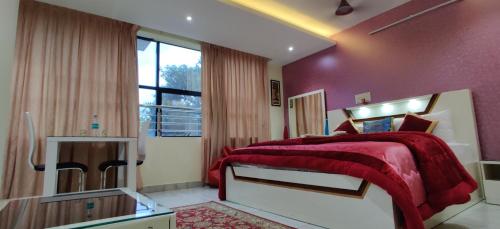 a bedroom with a bed with a red blanket at Rahul Residency in Mangalore