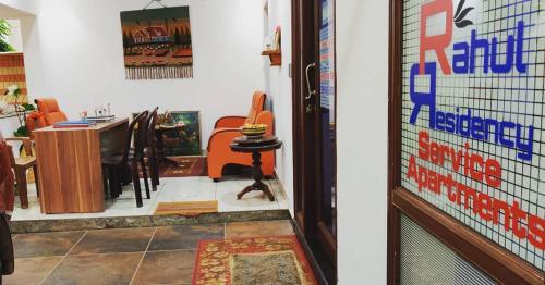 two pictures of a room with a table and a door at Rahul Residency in Mangalore