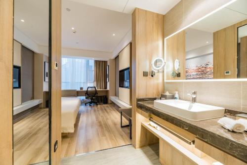 a bathroom with a sink and a bath tub at Atour Hotel (Tongxiang Zhenxing Road) in Tongxiang