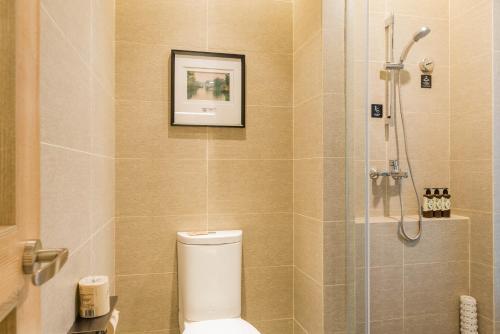 a bathroom with a toilet and a glass shower at Atour Hotel (Tongxiang Zhenxing Road) in Tongxiang