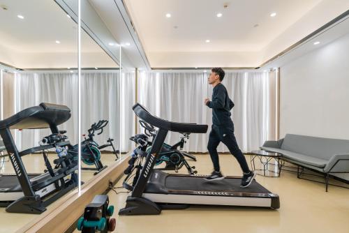a man walking on a treadmill in a gym at Atour Hotel (Tongxiang Zhenxing Road) in Tongxiang
