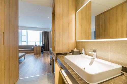 a bathroom with a sink and a mirror at Atour Hotel (Tongxiang Zhenxing Road) in Tongxiang