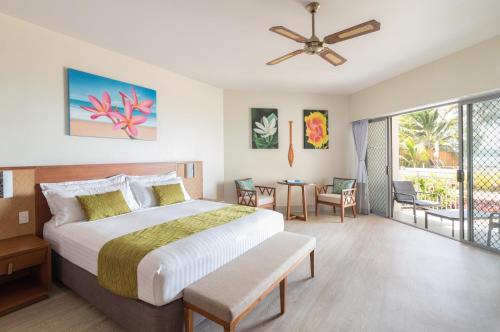 um quarto com uma cama grande e uma varanda em Moana Sands Lagoon Resort - Adults Only em Rarotonga