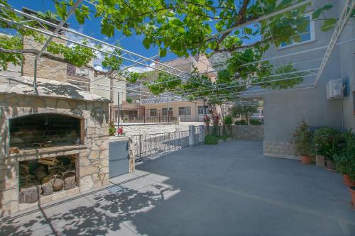a patio with a stone fireplace next to a house at Apartment Anica in Omiš