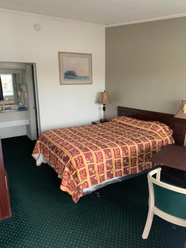a hotel room with a bed and a desk at Economy Inn Seaside in Seaside