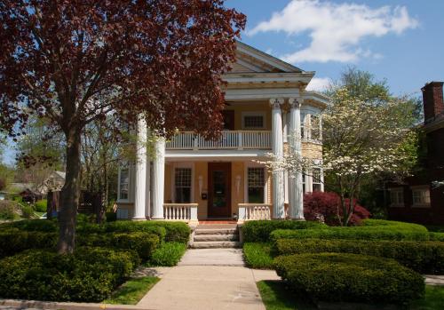 a white house with columns and a porch at Showers Inn in Bloomington