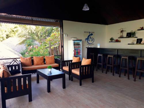 sala de estar con sofá, sillas y bar en Happy Gecko Dive Resort, en Bunaken