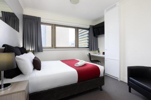 a hotel room with a bed and a desk at George Williams Hotel in Brisbane
