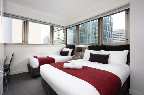 Habitación de hotel con 2 camas y ventanas en George Williams Hotel en Brisbane