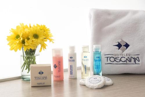 a group of three bottles ofodorizers on a table with a bag at Hotel Toscana Plaza in Cali