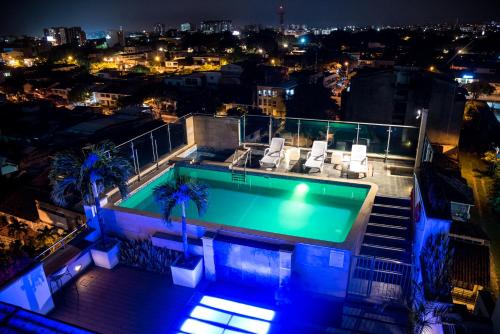 a swimming pool on the roof of a building at night at Hotel Toscana Plaza in Cali
