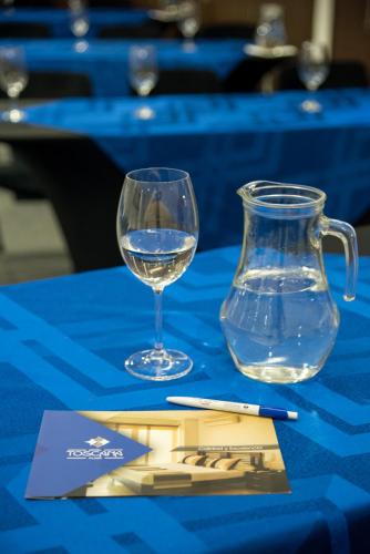a glass of water and a vase on a table at Hotel Toscana Plaza in Cali
