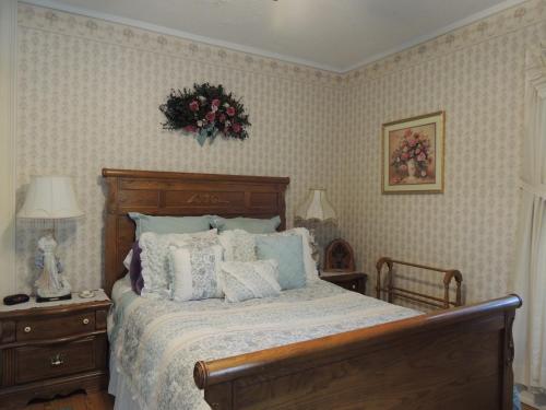 1 dormitorio con 1 cama con una corona de flores en la pared en Brookview Manor Inn en Canadensis