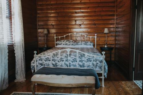 a bedroom with a bed with a wooden wall at Dubuque Bed and Breakfast in Numurkah