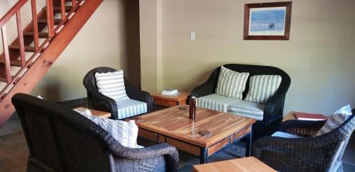 a living room with chairs and a table and a staircase at Milorho Lodge in Rietfontein