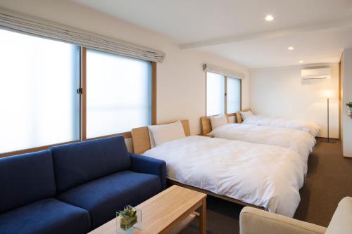 a living room with two beds and a couch at SO Kyoto Fushimi Inari in Kyoto