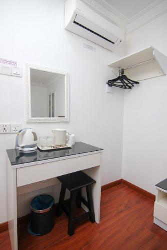 a white room with a desk and a mirror at Rose Cottage Hotel Taman Johor Jaya in Johor Bahru