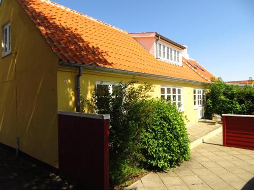 una casa gialla con tetto arancione di Skagen Villa & Apartments a Skagen