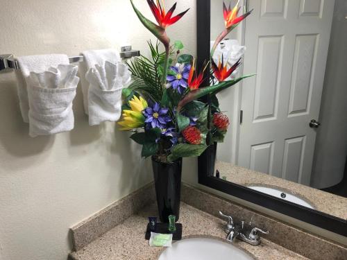 a vase of flowers sitting on a bathroom sink at Days Inn by Wyndham McDonough in McDonough