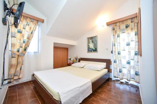a bedroom with a bed and a window at Bologna Apartments in Budva