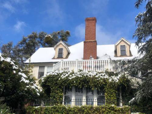 a white house with a chimney and a white fence at The Inn on Knowles Hill Bed & Breakfast Hotel in Sonora
